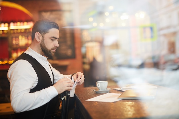 Uomo d'affari bello che lavora nel ristorante di lusso