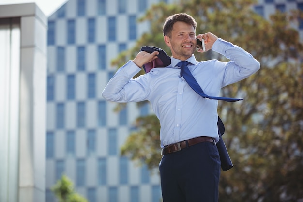 Uomo d'affari bello che parla sul telefono cellulare