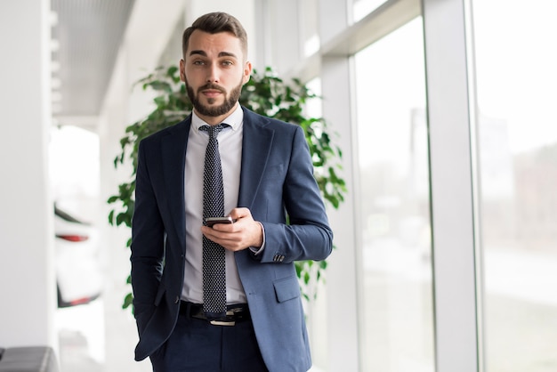 Uomo d'affari bello che propone nell'ufficio