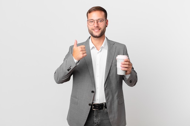 Uomo d'affari bello che tiene un caffè da asporto