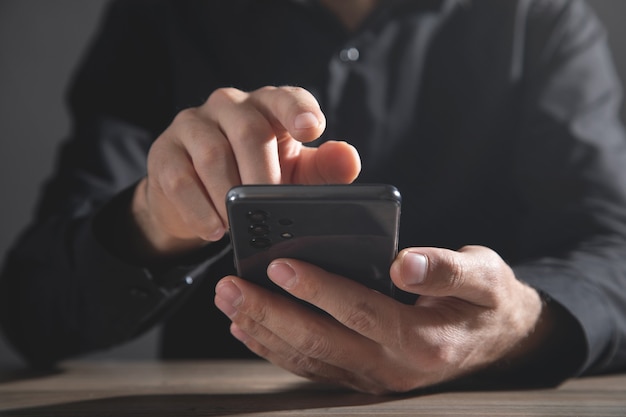 Uomo d'affari caucasico che utilizza smartphone in ufficio.