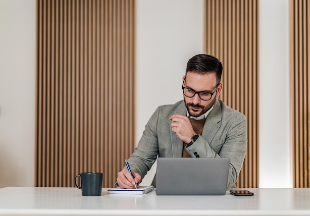 Uomo d'affari caucasico occupato che fa un programma per lavoro