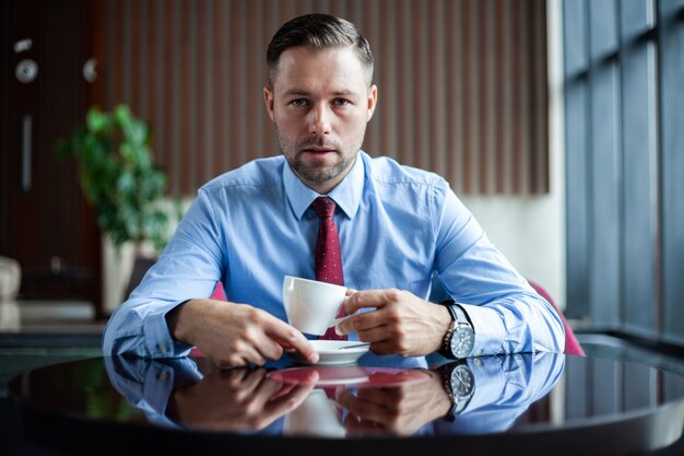 Uomo d'affari che beve caffè mentre pensa al nuovo progetto.