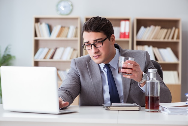 Uomo d'affari che beve in ufficio