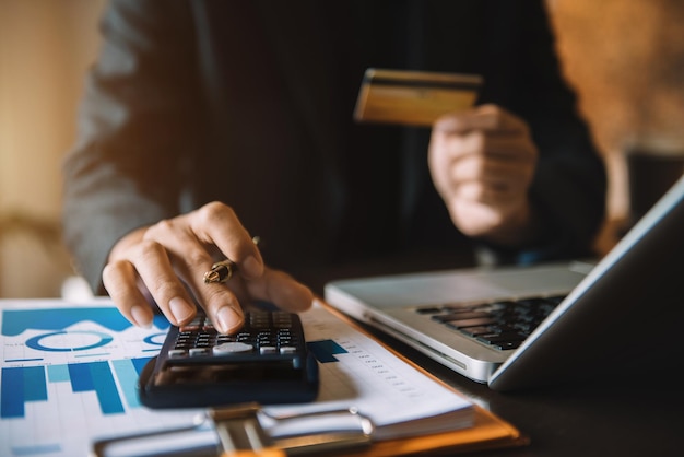 Uomo d'affari che calcola le spese mensili dell'ufficio tasse saldo del conto bancario e pagamento delle bollette della carta di credito Il reddito non è sufficiente per le spese in ufficio