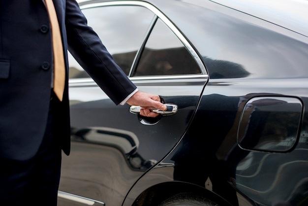 Uomo d&#39;affari che entra nella sua auto