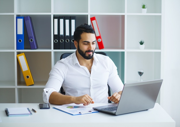 Uomo d'affari che lavora al computer portatile nel suo ufficio