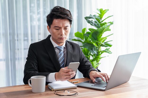 Uomo d'affari che lavora al computer portatile per l'area di lavoro della scrivania dell'ufficio Giubilante