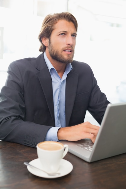 Uomo d&#39;affari che lavora sul suo computer portatile