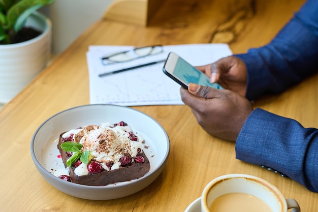 Uomo d'affari che mangia il dessert al caffè