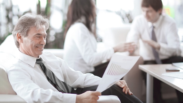 uomo d'affari che medita su un documento seduto in un ufficio moderno.foto con spazio di copia