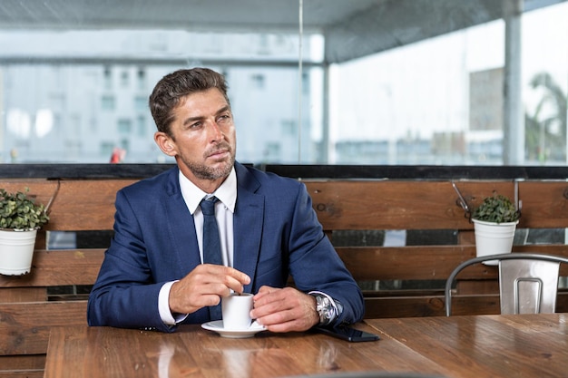 Uomo d'affari che mescola caffè in tazza