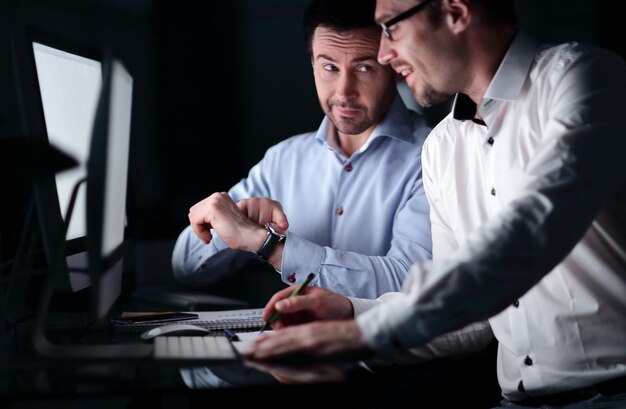 Uomo d'affari che mostra collega al suo watchthe concetto di lavoro straordinario