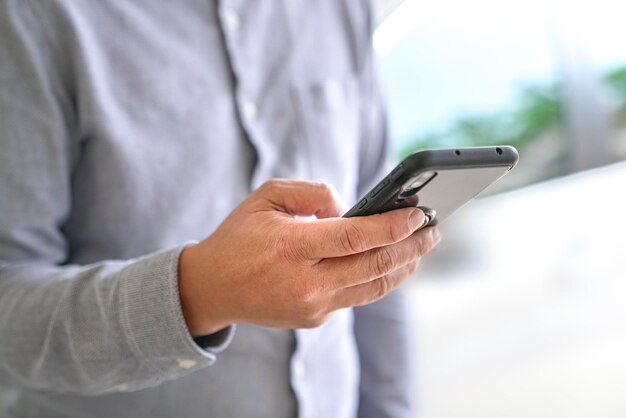 Uomo d'affari che naviga o naviga sul suo cellulare