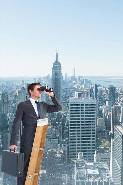 Uomo d'affari che osserva su una scala contro l'orizzonte di New York