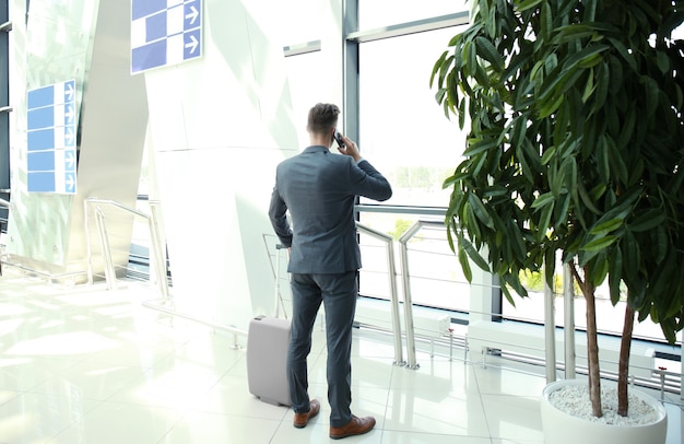 Uomo d'affari che parla al telefono in aeroporto.