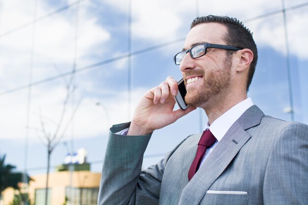 uomo d'affari che parla con telefono cellulare all'aperto