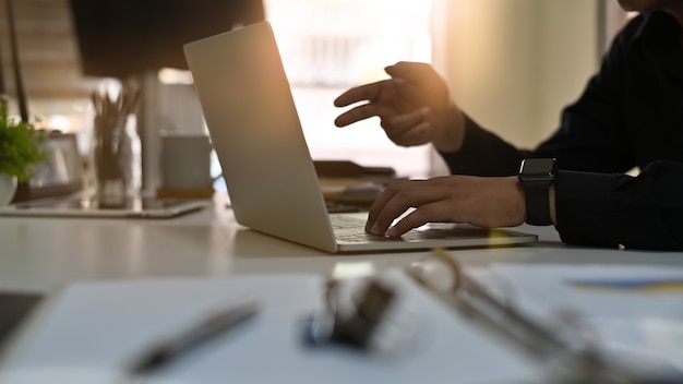 Uomo d'affari che per mezzo del computer portatile sulla tabella.