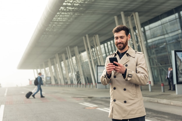 Uomo d'affari che per mezzo dello smartphone mentre camminando