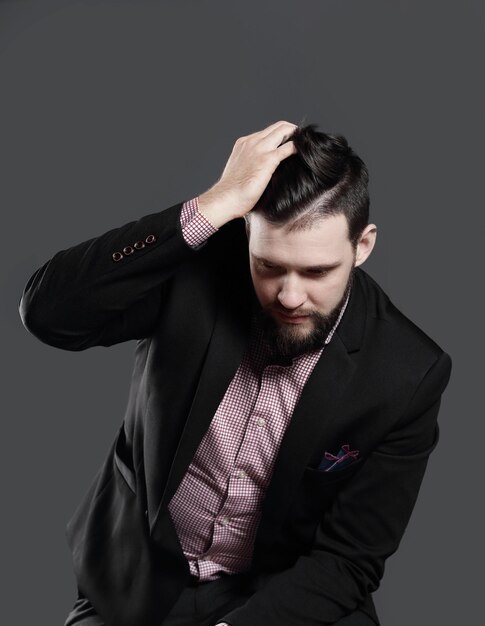 Uomo d'affari che regola il suo hairisolated su sfondo grigio