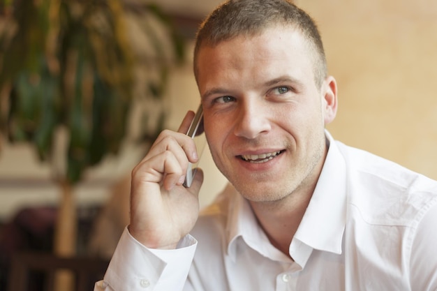 Uomo d'affari che risponde allo smartphone in ufficio