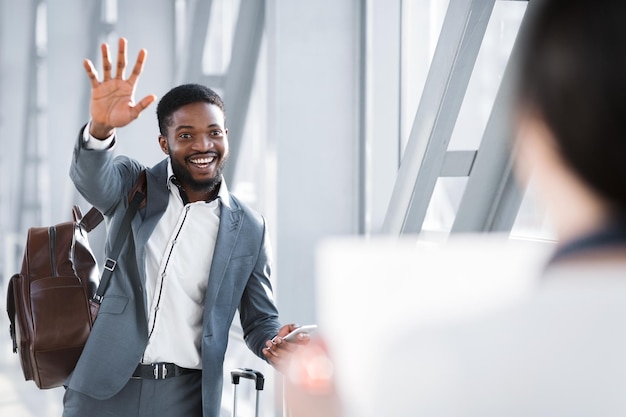 Uomo d'affari che saluta il partner che lo aspetta in aeroporto