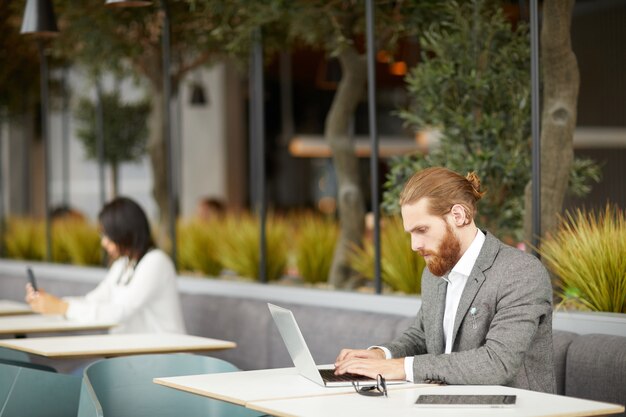 Uomo d'affari che si siede in caffè online