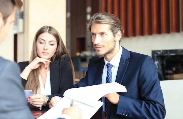 Uomo d'affari che sorride felicemente come suo socio in affari che finalmente firma un contratto importante.