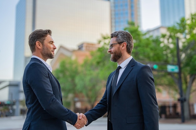 Uomo d'affari che stringe la mano due uomini d'affari stretta di mano stretta di mano all'aperto uomini d'affari motivazione