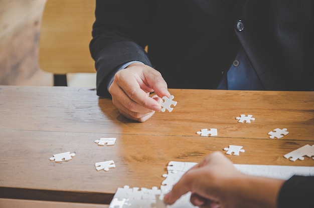 Uomo d'affari che tiene puzzle bianco e si collega insieme