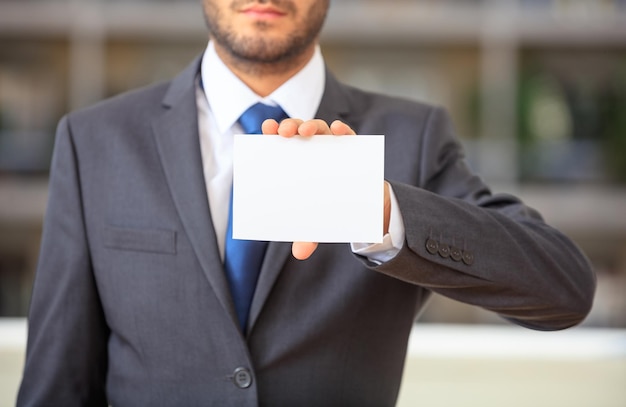 Uomo d'affari che tiene una carta in bianco