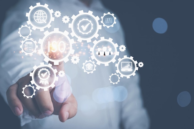 Uomo d'affari che tocca lo schermo virtuale ISO con le icone di affari sugli ingranaggi Concetto di controllo qualità standardizzazione della certificazione ISO sullo schermo