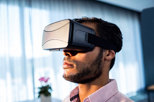 Uomo d'affari che usando una cuffia avricolare del vr