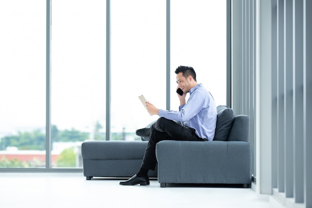 Uomo d'affari che utilizza cellulare nell'ufficio.