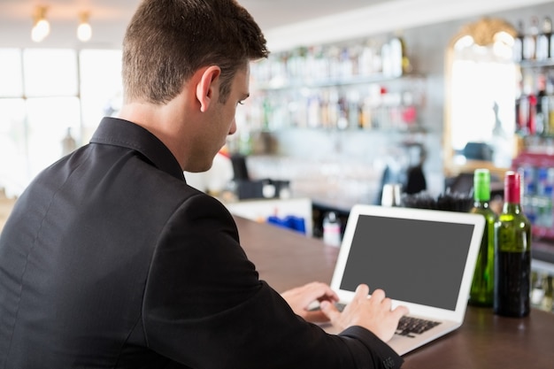 Uomo d'affari che utilizza computer portatile nel ristorante