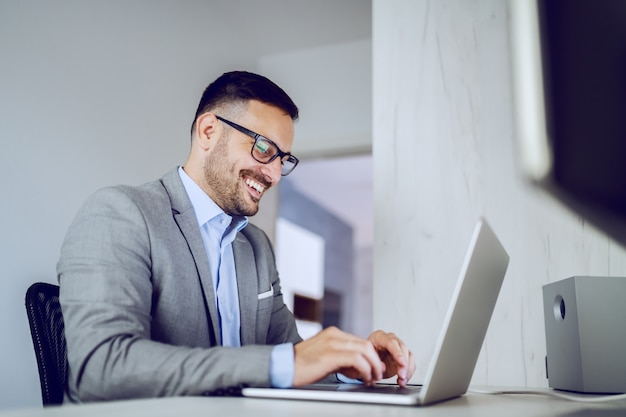 Uomo d'affari che utilizza computer portatile nell'ufficio.