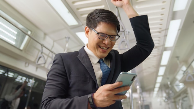 Uomo d'affari che utilizza il telefono cellulare sul treno pubblico. Concetto di pendolarismo urbano stile di vita.