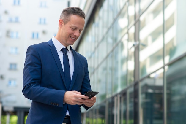 Uomo d'affari che utilizza il telefono per inviare un messaggio