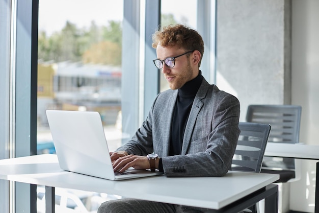 Uomo d'affari che utilizza l'avvio della pianificazione del computer portatile che lavora online in un ufficio moderno