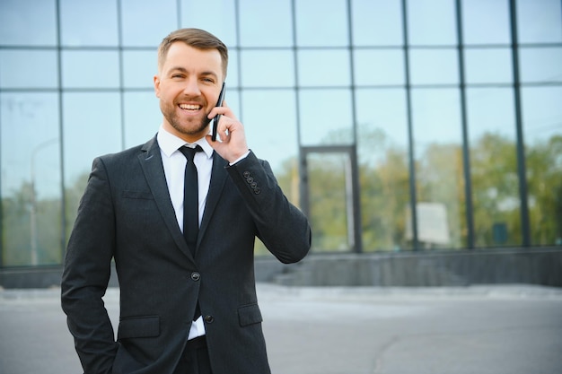 Uomo d'affari che utilizza smartphone nel passaggio coperto