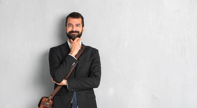 Uomo d&#39;affari con barba sorridente e guardando in avanti con la faccia fiduciosa