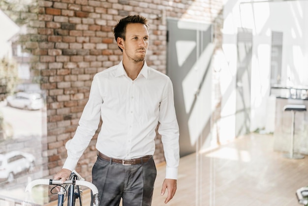 Uomo d'affari con la bicicletta in ufficio