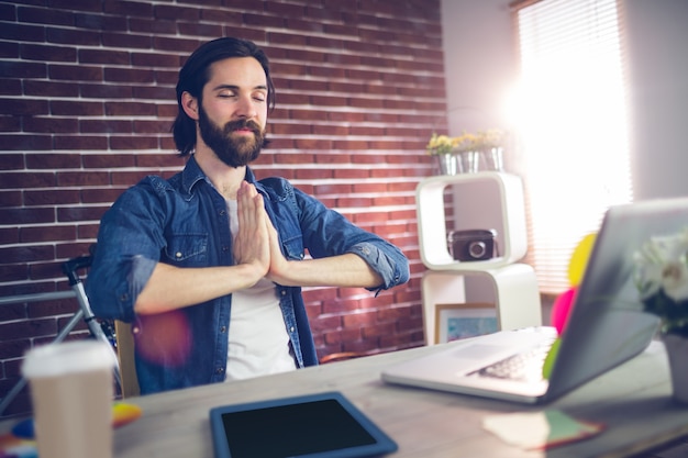 Uomo d&#39;affari con la mano clasped facendo yoga