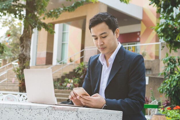 Uomo d&#39;affari con laptop e smartphone