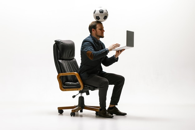Uomo d'affari con pallone da calcio in ufficio