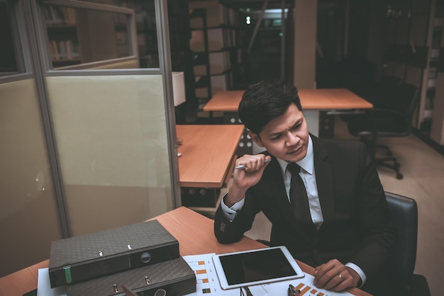 Uomo d'affari con stress asiatico che lavora fallitoIl proprietario dell'azienda lo ha incolpato di parolacceImpiegato tailandese serio per il duro lavoro del capoTriste bel ragazzo in abito nero