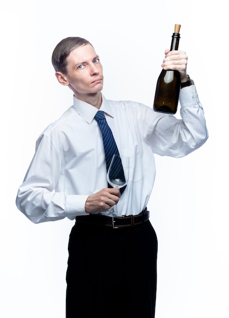 Uomo d'affari con un bicchiere e una bottiglia di vino nelle sue mani su uno sfondo bianco isolato xA