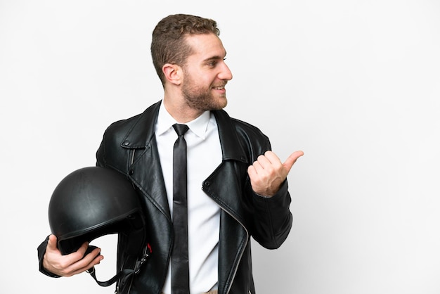 Uomo d'affari con un casco da motociclista su sfondo bianco isolato che punta al lato per presentare un prodotto