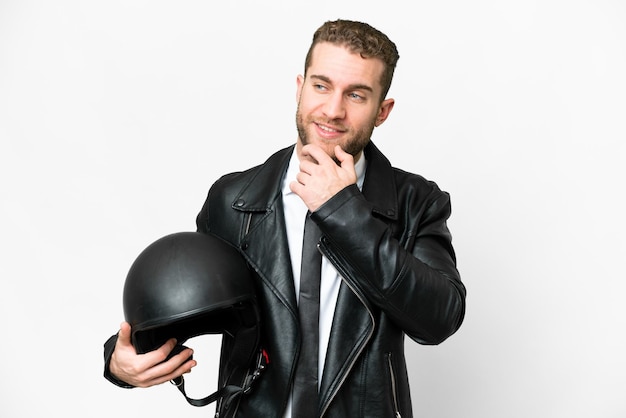 Uomo d'affari con un casco da motociclista su sfondo bianco isolato guardando al lato e sorridente