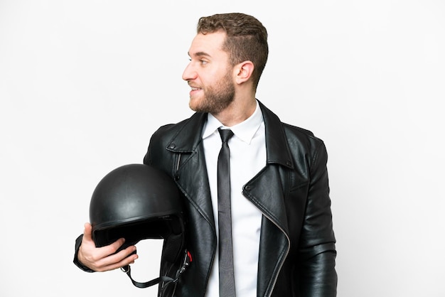 Uomo d'affari con un casco da motociclista su sfondo bianco isolato guardando il lato